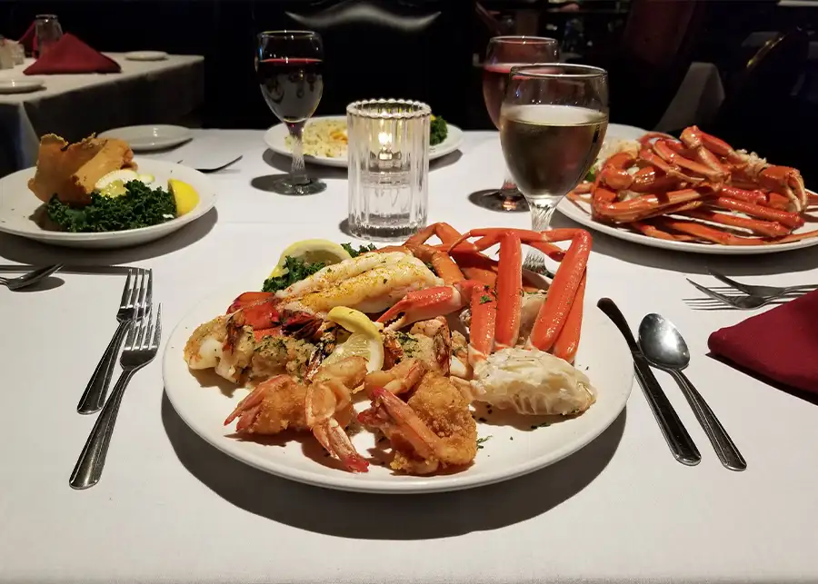 Chesapeake Seafood House - dining table with food, crab legs and shrimp - Decatur, IL